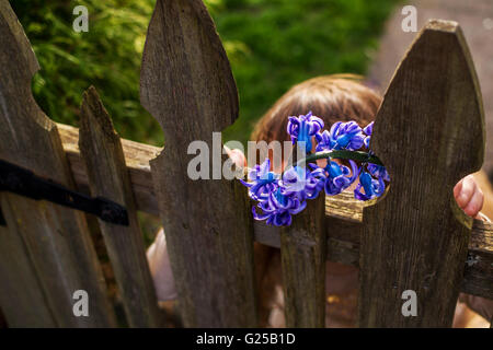 Mädchen mit Hyazinthenblumen Holztor im Garten stehen Stockfoto