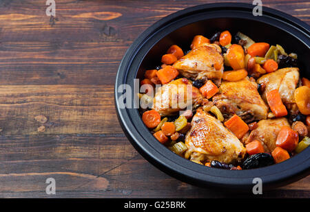 Tajine mit gekochtem Hühnerfleisch und Gemüse. Traditionelle marokkanische Küche. Hölzerne Hintergrund Textfreiraum. Stockfoto