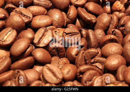 Vollformat-Hintergrundtextur eines Haufens frisch gerösteter brauner Kaffeebohnen, die ein reichhaltiges organisches Muster bilden Stockfoto