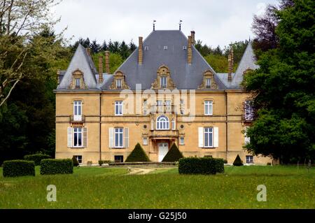 Ehemalige Burg im Wald mit einem Weg von Bäumen und eine große Liegewiese. Stockfoto