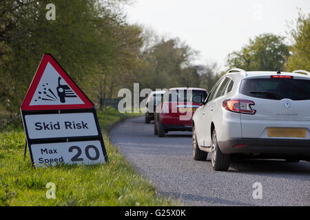 Neu Straßenbelag und zugehörigen Skid Risiko verlangsamt Verkehr auf der britischen Landstraße. Stockfoto