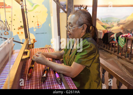 Thai Frau arbeitet mit alten Seidenweberei Handwerk Maschine Tai Dam Stil in Seidenfabrik in Nordthailand Stockfoto