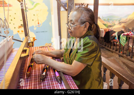 Thai Frau arbeitet mit alten Seidenweberei Handwerk Maschine Tai Dam Stil in Seidenfabrik in Nordthailand Stockfoto