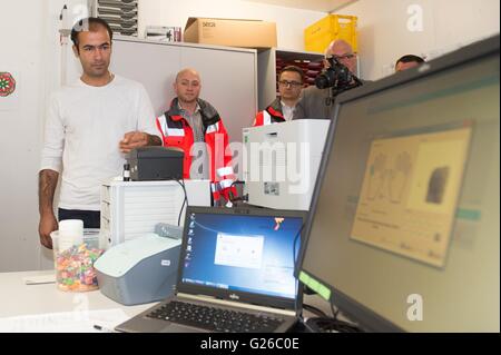 Iranische Mohammadi Nasir legt seine Hand auf einen Fingerabdruck-Scanner für ein Zertifikat-Ankunft in Dresden, Deutschland, 25. Mai 2016 bewerben. Am selben Tag wurden die neuen Beweise der Ankunft für Asylsuchende in Sachsen vorgestellt. Die Zertifikate der Beweis sind Teil eines neuen Systems für eine landesweit einheitliche Registrierung der Flüchtlinge. Foto: Sebastian Kahnert/dpa Stockfoto