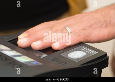 Iranische Mohammadi Nasir legt seine Hand auf einen Fingerabdruck-Scanner für ein Zertifikat-Ankunft in Dresden, Deutschland, 25. Mai 2016 bewerben. Am selben Tag wurden die neuen Beweise der Ankunft für Asylsuchende in Sachsen vorgestellt. Die Zertifikate der Beweis sind Teil eines neuen Systems für eine landesweit einheitliche Registrierung der Flüchtlinge. Foto: Sebastian Kahnert/dpa Stockfoto