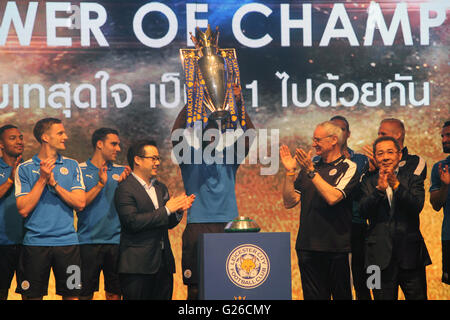 Bangkok, Thailand. 18. Mai 2016. Leicester City FC Kapitän Wes Morgan hebt die Trophäe als der Club-Besitzer Vichai Srivaddhanaprabha und seinem Sohn stellvertretende Vorsitzende Aiyawatt Srivaddhanaprabha, und Trainer Claudio Ranieri applaudieren, während einer Präsentation der englischen Premier League Trophy Hauptquartier der King Power Duty Free in Bangkok. Stockfoto