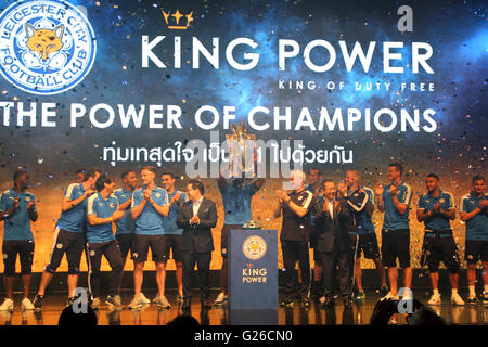 Bangkok, Thailand. 18. Mai 2016. Leicester City FC Kapitän Wes Morgan hebt die Trophäe als der Club-Besitzer Vichai Srivaddhanaprabha und seinem Sohn stellvertretende Vorsitzende Aiyawatt Srivaddhanaprabha, und Trainer Claudio Ranieri applaudieren, während einer Präsentation der englischen Premier League Trophy Hauptquartier der King Power Duty Free in Bangkok. Stockfoto