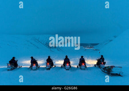 Motorschlitten mit schneebedeckten Bergen Longyearbyen bei Dämmerung, Svalbard, Spitzbergen, Norwegen Stockfoto