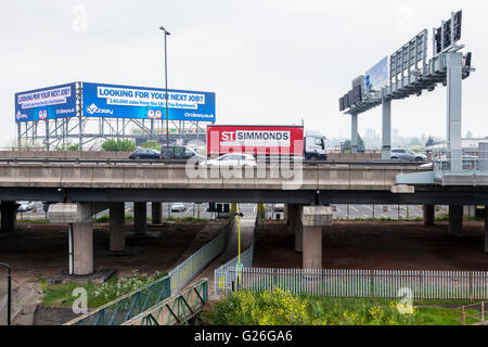 Autobahn M6 mit einer Straße zu unterzeichnen, Gantry und hohen Niveau elektronischer Werbung Plakat, Bescot, Walsall, West Midlands, England, UK Stockfoto