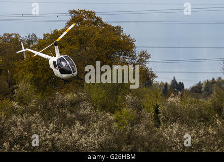 Ein Zweisitzer Robinson R22 Helikopter, G-HONI, nähert sich eine Landung am Flugplatz Elstree in Hertfordshire, Großbritannien Stockfoto