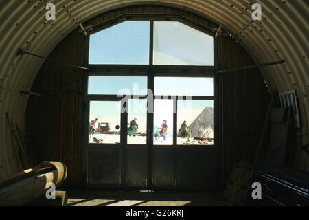 Blick aus einem Fenster an der Zugspitze Cog Railway Station.  Menschen genießen Wintersport, Zugspitze Gletscherplateau, Deutschland. Stockfoto