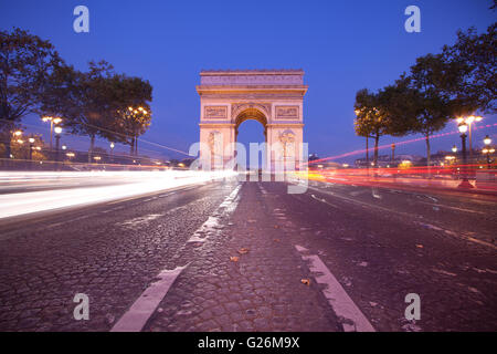 Vorderansicht des Arc de Triomphe (Triumphbogen) in Paris in der Abenddämmerung mit Ampel-trail Stockfoto