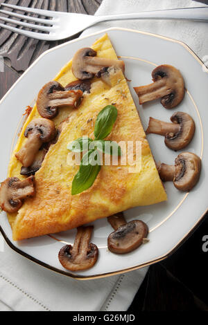 Omelette mit Pilzen auf einem Holztisch von oben gesehen Stockfoto