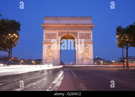 Vorderansicht des Arc de Triomphe (Triumphbogen) in Paris in der Abenddämmerung mit Ampel-trail Stockfoto