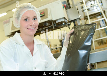 Porträt der Dame Fabrik Holding versiegelt schwarze Tasche Stockfoto