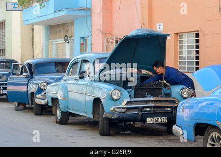 Ein kubanische Mann Dienstleistungen seinen amerikanischen Oldtimer in Havanna, Kuba Stockfoto