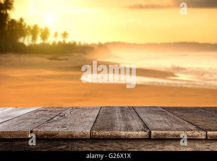 Sonnenuntergang am sandigen Sommerstrand mit Palmen und leere Holzbohlen, ideal für Product placement Stockfoto