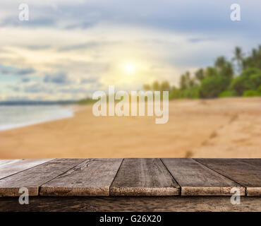 Sonnenuntergang am sandigen Sommerstrand mit Palmen und leere Holzbohlen, ideal für Product placement Stockfoto