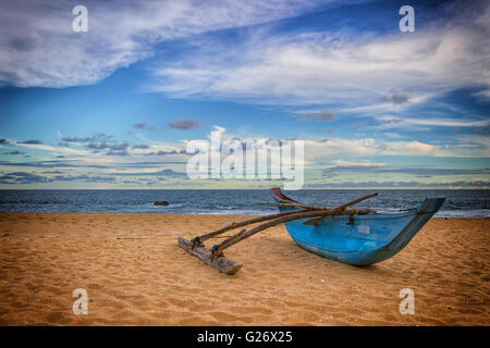 Alten blauen Fischerboot am Sandstrand in dramatischen Licht Stockfoto