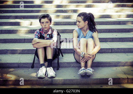 müde Reisende Geschwister sitzen auf Stufen Stockfoto