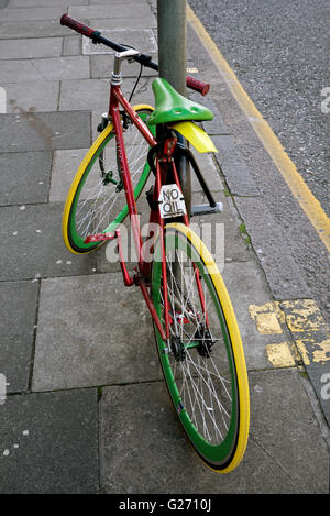 Rot, grün und gelb gefärbten Fahrrad mit einem "kein Öl" Schild angebracht. Stockfoto