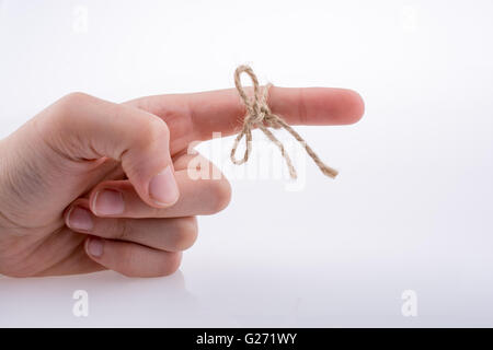 Hand gebunden mit einem Faden wie ein Band auf weißem Hintergrund Stockfoto