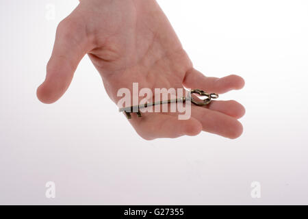 Hand halten, dass eine Retro Stil Metallschlüssel auf weißem Hintergrund Stockfoto