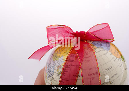 Globus, gebunden mit rotem Band auf weißem Hintergrund Stockfoto