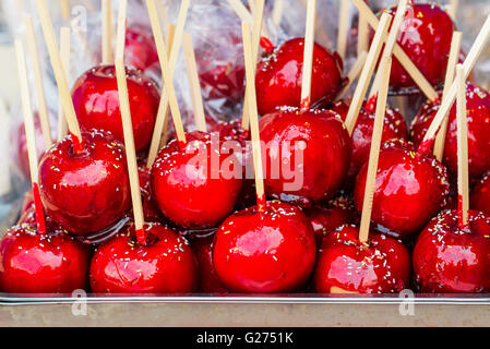 Sweet glasiert rote Toffee Liebesäpfel auf Sticks für den Verkauf auf dem Wochenmarkt oder Jahrmarkt. Stockfoto