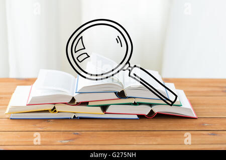 Nahaufnahme von Büchern auf Tisch mit Lupe doodle Stockfoto
