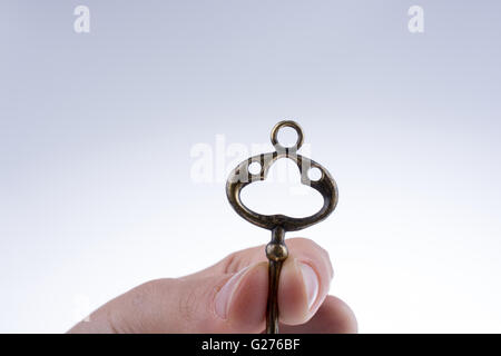 Hand halten, dass eine Retro Stil Metallschlüssel auf weißem Hintergrund Stockfoto