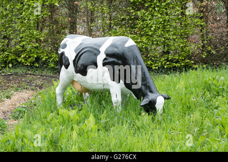 Beweidung von schwarzen und weißen Friesen Kunststoff Kuh Skulptur Stockfoto