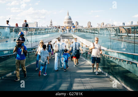 London, UK - 22. August 2015: Menschen, die zu Fuß über die Millennium Brücke einen sonnigen Tag. St Pauls Cathedral im Hintergrund. Stockfoto