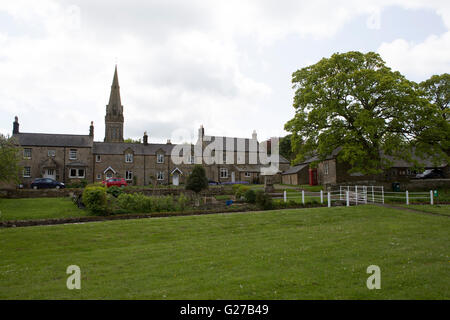 Den Dorfanger in Matfen, England. Ein versunkene Stream führt vorbei an den grünen und der Turm der Kirche steht in der Ferne. Stockfoto