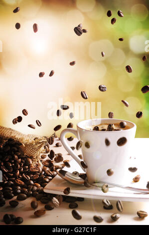 Tasse Kaffee auf weißem Holz und Grün Natur Hintergrund. Ansicht von vorne. Vertikale Zusammensetzung Stockfoto