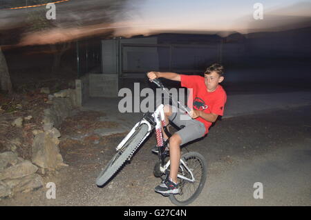 Ein Junge einen Wheelie ziehen Stockfoto