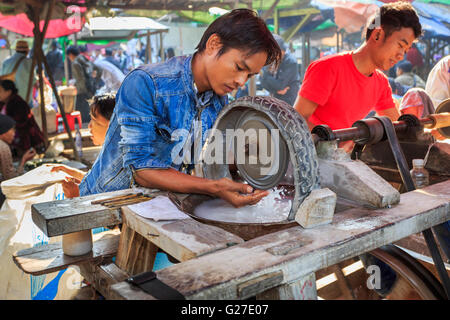 Junge Handwerker vor Ort arbeiten beim Polieren jade mit einem Rad auf dem Jademarkt, Mandalay, Myanmar (Burma) Stockfoto