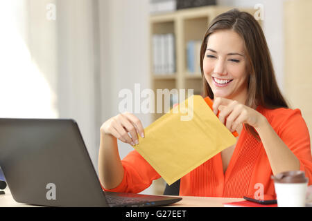 Freelancer in einem gepolsterten Umschlag zu öffnen, im Büro oder Zuhause Stockfoto