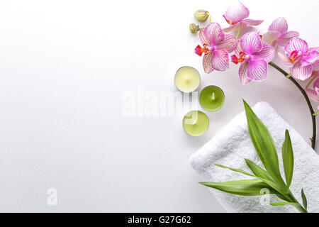 Handtuch, Orchideenblüten, Bambusblatt und Kerze Stockfoto