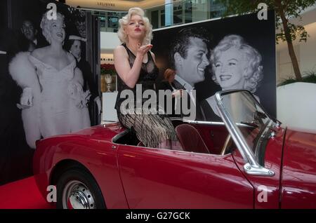 Offiziellen Marilyn Monroe Lookalike Suzie Kennedy posiert auf einem Oldtimer, das Vermächtnis einer Legende-Ausstellung im Design Centre in London zu starten. Stockfoto