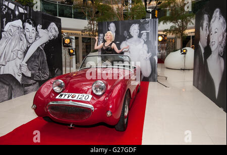 Offiziellen Marilyn Monroe Lookalike Suzie Kennedy posiert auf einem Oldtimer, das Vermächtnis einer Legende-Ausstellung im Design Centre in London zu starten. Stockfoto