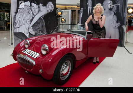 Offiziellen Marilyn Monroe Lookalike Suzie Kennedy posiert auf einem Oldtimer, das Vermächtnis einer Legende-Ausstellung im Design Centre in London zu starten. Stockfoto