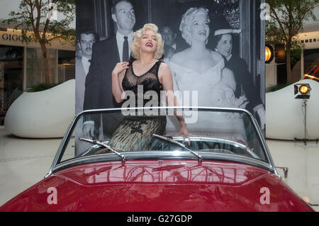 Offiziellen Marilyn Monroe Lookalike Suzie Kennedy posiert auf einem Oldtimer, das Vermächtnis einer Legende-Ausstellung im Design Centre in London zu starten. Stockfoto