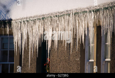 Sonnenlicht trifft Eiszapfen hängen von einem Haus in den Scottish Borders Stockfoto