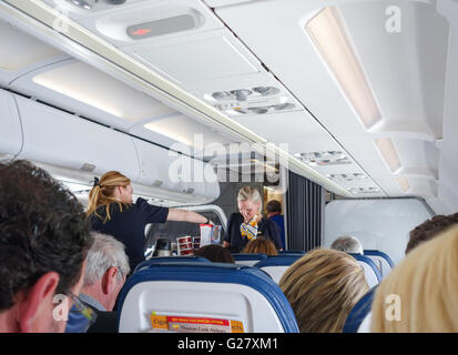 Flugbegleiterinnen, die Speisen und Getränke an Bord einer Thomas Cook Airlines Airbus A321 Flugzeug Stockfoto