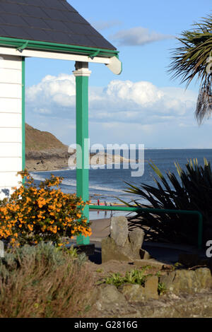 Bunte Badehäuschen überblicken Langland Bucht, Gower, Swansea mit Wellen im Hintergrund.  Strand-Lebensstil. Stockfoto