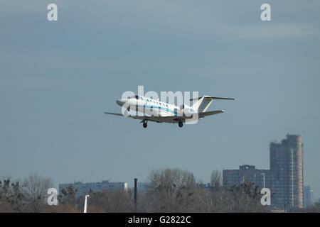 Kiew, Ukraine - 24. März 2011: Cessna 525B Citation Jet CJ3 vom Flughafen mit der Stadt im Hintergrund hebt ab Stockfoto