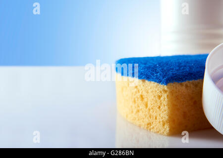 Reinigung Produkte und Geräte zu weißen Tisch und blauem Hintergrund hautnah. Ansicht von vorne. Horizontale Komposition. Stockfoto