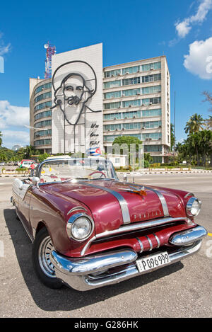 1955 Pontiac Star Chief geparkt am Platz der Revolution vor dem Bild der revolutionäre Guerilla-Kämpfer Camilo Cienfuegos. Stockfoto