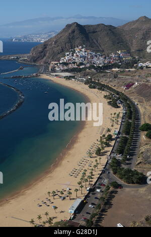 Playa de Las Teresitas mit dem Dorf San Andrés thront auf dem Berghang und Santa Cruz De Tenerife in weiter Ferne Stockfoto